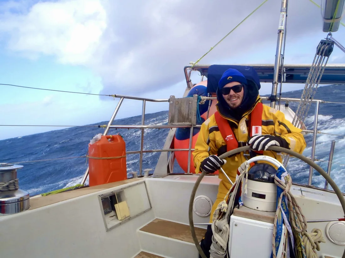 A young Jordan grinning at the wheel in heavy Southern Ocean seas